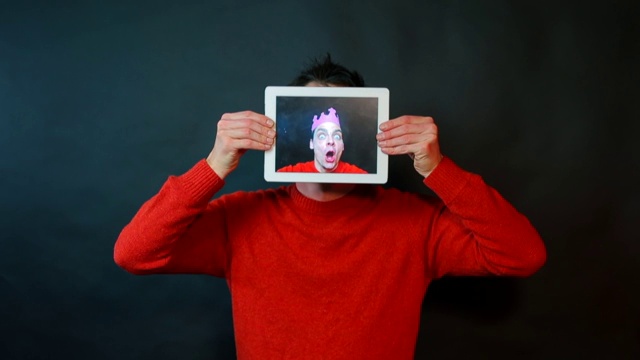 一个手里拿着平板电脑的人的肖像。视频下载