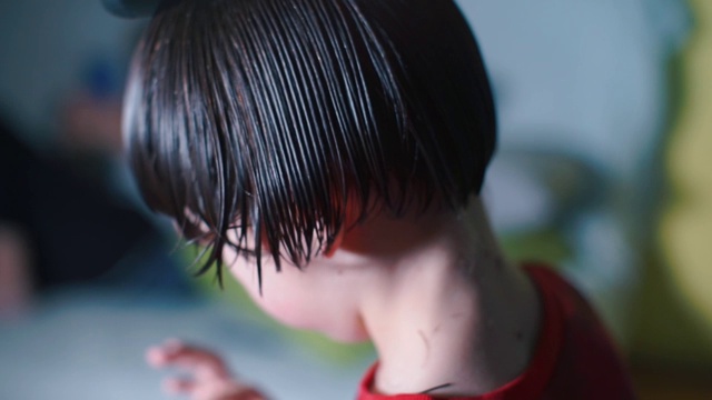理发师给一个十几岁的少年剪下了湿发的发梢。视频下载