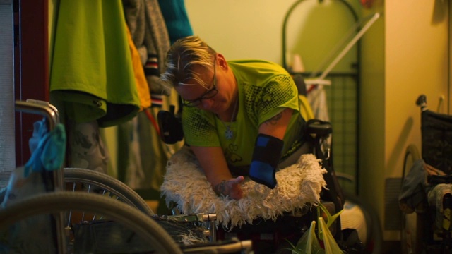 残疾妇女正在准备从轮椅到另一把椅子的经历。视频下载