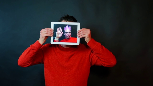 一个男人拿着一个平板，而不是脸。视频下载