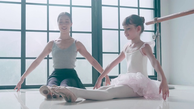 亚洲老师和她可爱的芭蕾舞女演员上芭蕾课视频素材