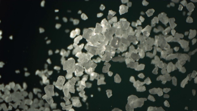盐是在空气中高速飞行在绿色的水Menthe彩色背景拍摄1000 fps 4K视频下载
