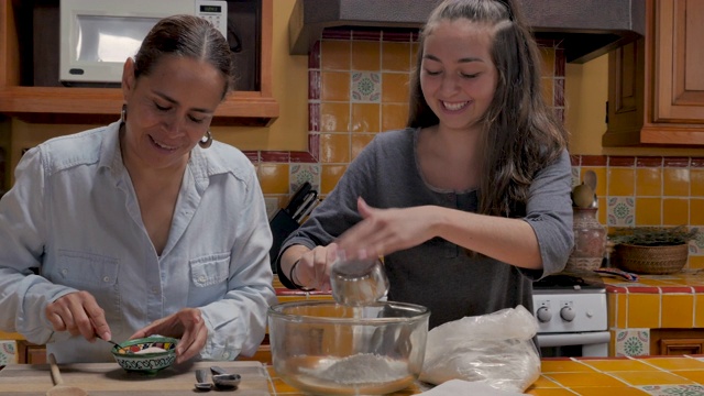 迷人的母亲和美丽的女儿一起工作烘焙和烹饪视频素材