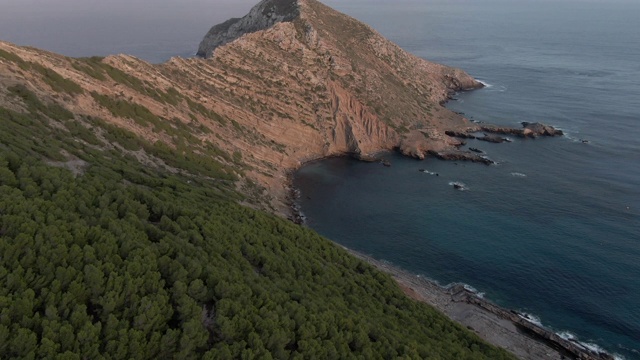 一架无人机拍摄的一个靠近海洋的有树的半岛视频素材