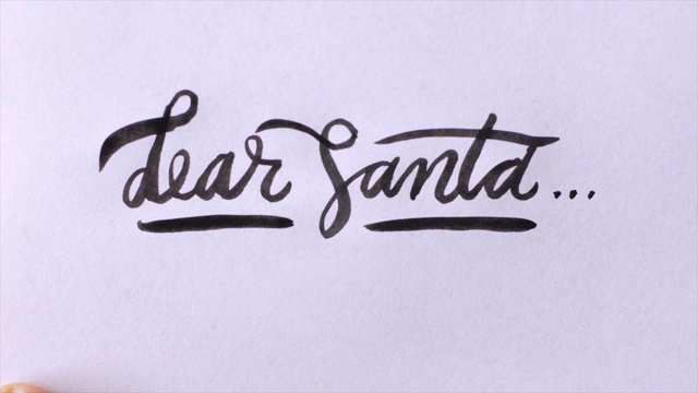 用黑墨水在白纸上手写“亲爱的圣诞老人”草书视频素材