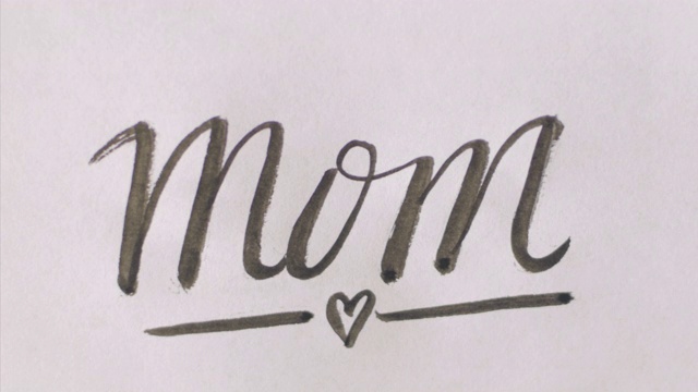 在白纸上手写一个心形的“MOM”(妈妈)视频下载