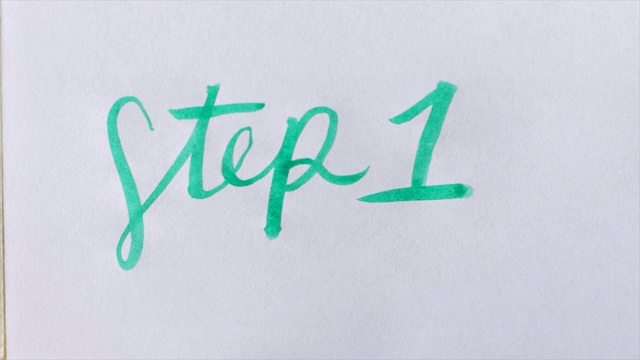 用绿色毛笔在白纸上写出草书第一步视频素材