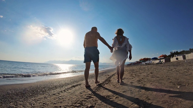 一对老年情侣在海滩上散步视频素材