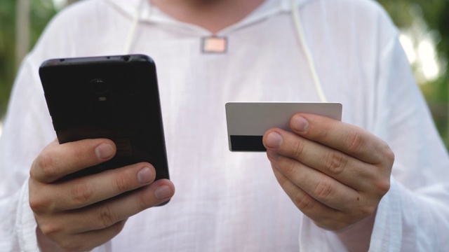 男子使用黑色智能手机和支付卡视频素材