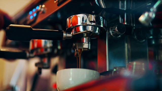 咖啡店的咖啡师会把咖啡从机器滴进杯子里视频素材