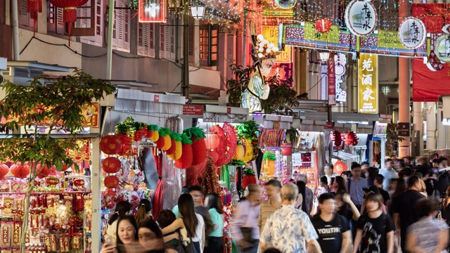 镜头聚焦中国新年期间的中国城，展示了一个繁忙的夜市和挤满了新年装饰品的街道视频素材