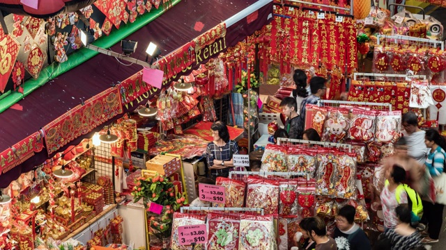 中国农历新年期间的唐人街，展示了一个繁忙的夜市和挤满了新年装饰品的街道视频素材