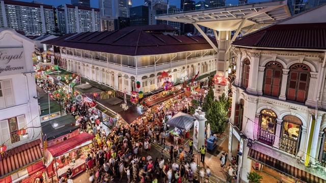 WS/TL/ZI/PD从白天到夜晚的转换/放大/平移中国城在中国新年期间的时间流逝，展示了一个繁忙的夜市和拥挤的街道映衬着新加坡的天际线视频下载