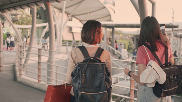 两名女游客边走边用手机，慢镜头视频素材