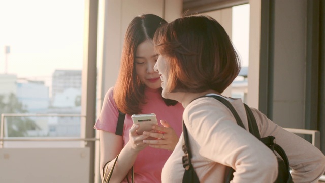 两名女游客在用智能手机聊天，RAW VDO的慢镜头视频素材