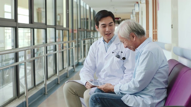 年轻的亚洲医生向年长的病人展示化验结果视频下载