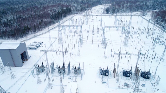 变电站将电流分配到被雪覆盖的树木上视频素材