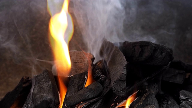 燃烧着的木炭在烧烤时在火盆里烧烤燃烧着的煤炭。视频素材