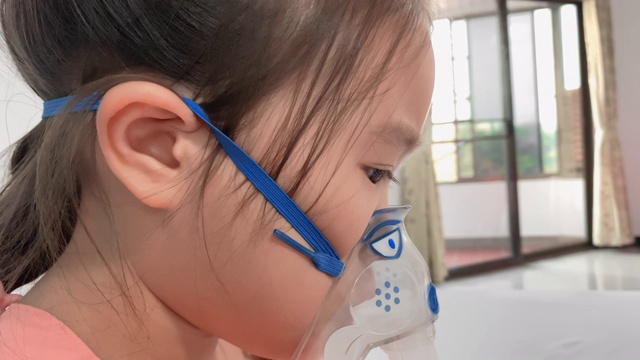 生病的儿童女孩戴着喷雾器面罩在医院里视频素材