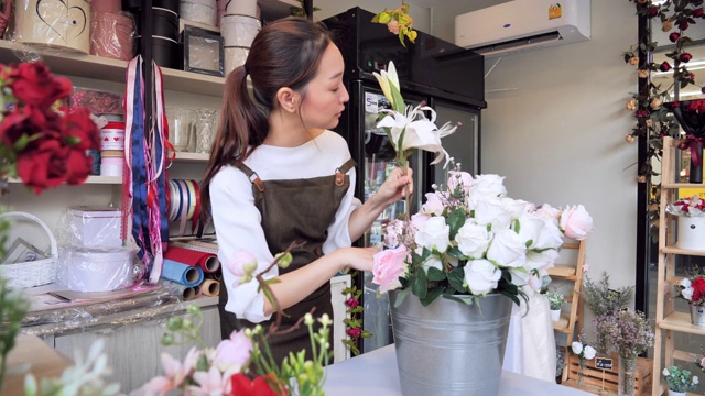 拥有花店的亚洲女人花店内准备出售，有专业的日本女人花店，花店在城市中，小的经营理念。视频下载
