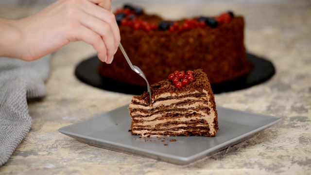 一块法国巧克力拿破仑蛋糕松饼与浆果在盘子上特写。吃巧克力蛋糕。视频素材