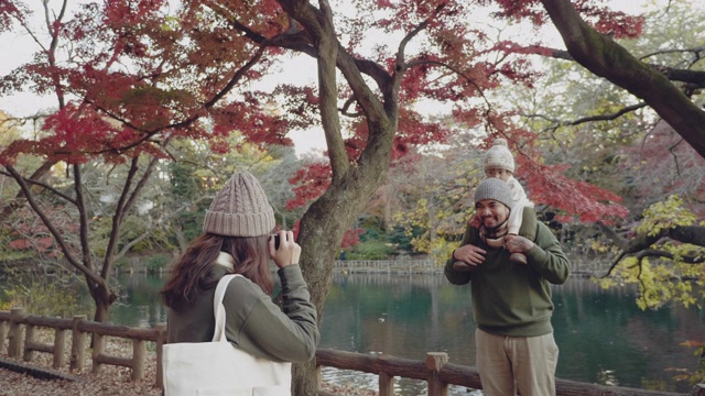 亚洲母亲在一个美丽的公园里拍摄她的家人在秋天的时间视频素材