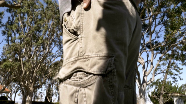 一个男人的低角度，他的手在他的工装裤的后口袋视频下载