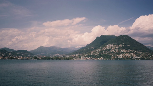 风景优美的瑞士小镇，拥有豪华别墅。是南欧著名的旅游胜地。卢加诺湖的全景，山脉和城市卢加诺，提契诺坎顿，瑞士。视频下载