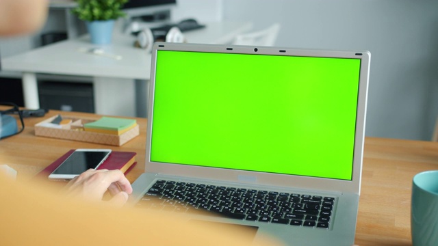 特写男性的手使用绿色屏幕色度键笔记本电脑在办公室打字视频素材