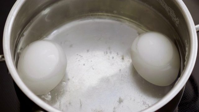 这是两个白色鸡蛋在一锅沸水中的特写。4 k视频素材