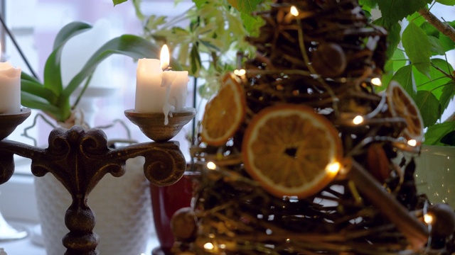 特写两个点燃的白色圣诞蜡烛在一个古董烛台。4 k视频下载