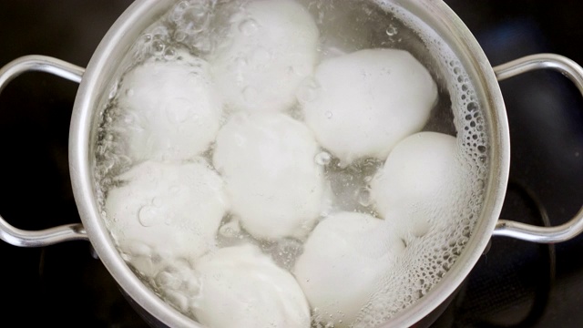 8个白色鸡蛋放在一锅沸水里的特写。4 k视频素材