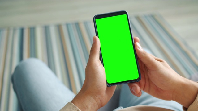 男性手握当代智能手机与绿色色度键屏幕视频素材