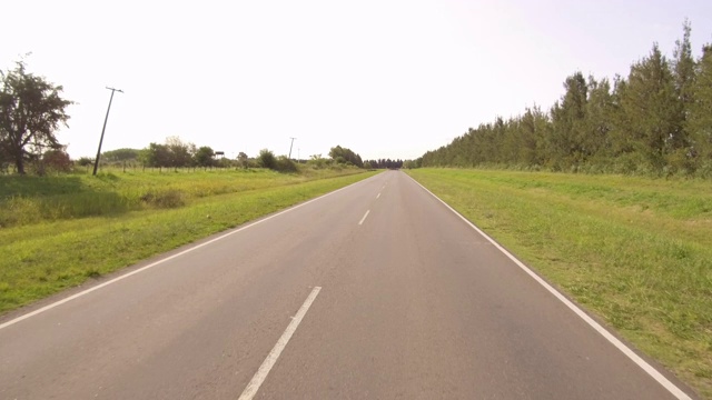 驾驶骑一辆汽车在一个乡村边的道路，山谷- POV板-观点前面视频下载