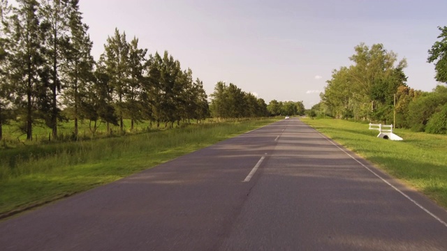 驾驶骑一辆汽车在一个乡村边的道路，山谷- POV板-观点前面视频下载