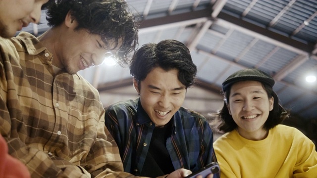 一群日本男孩在智能手机上看视频(慢镜头)视频下载