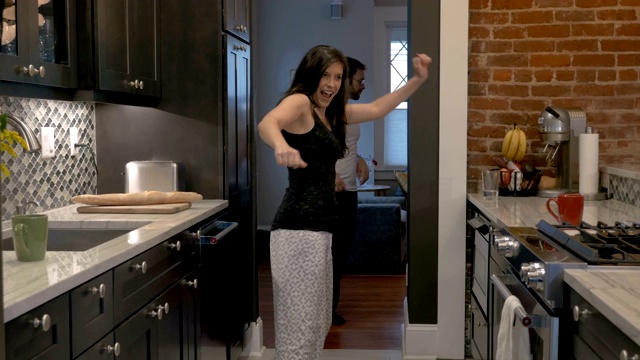 漂亮的年轻夫妇跳着舞走进厨房视频素材