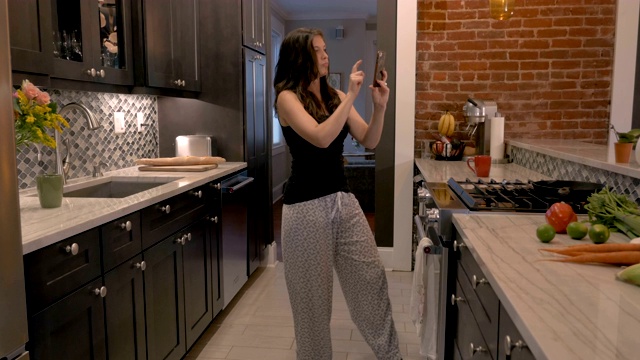一个女人带着她的智能手机翩翩起舞视频素材