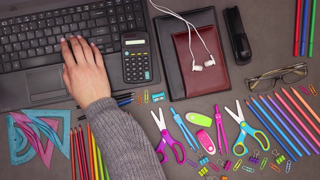 女人在笔记本电脑键盘上打字，在办公空间商务桌上的计算器上计算-停止运动视频下载