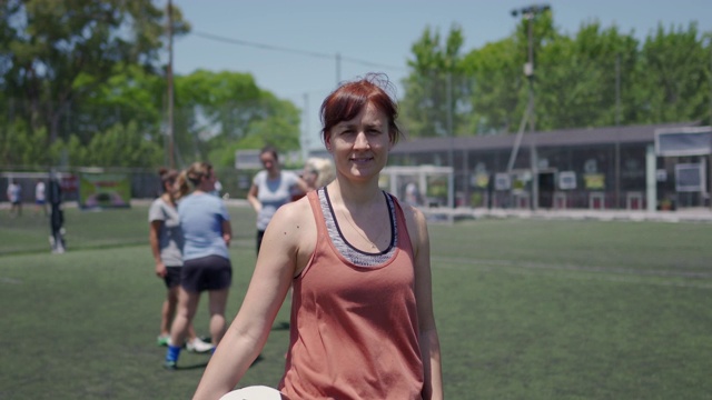 女足球运动员抱着球站在足球场上视频素材