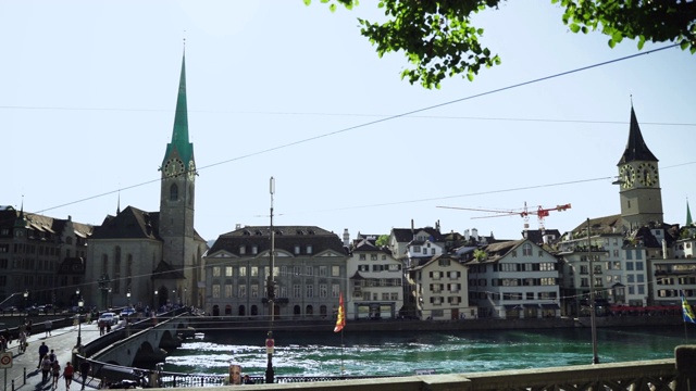 在一个阳光明媚、天空湛蓝的日子里，瑞士苏黎世州的利马特河上有著名的弗劳姆蒙斯特教堂，历史悠久的苏黎世市中心美景尽收眼底视频下载