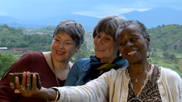 三名活泼的60多岁老年女性度假时用智能手机自拍视频素材