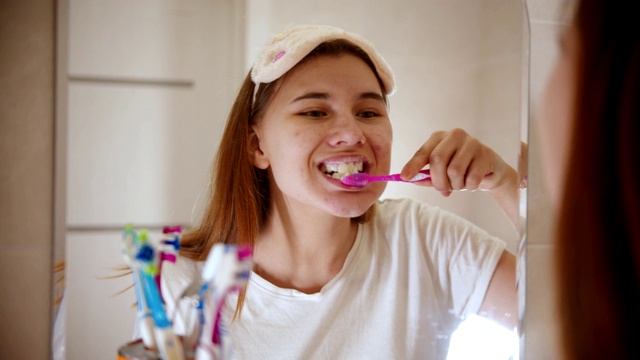 一个年轻的女人在早上刷牙视频素材