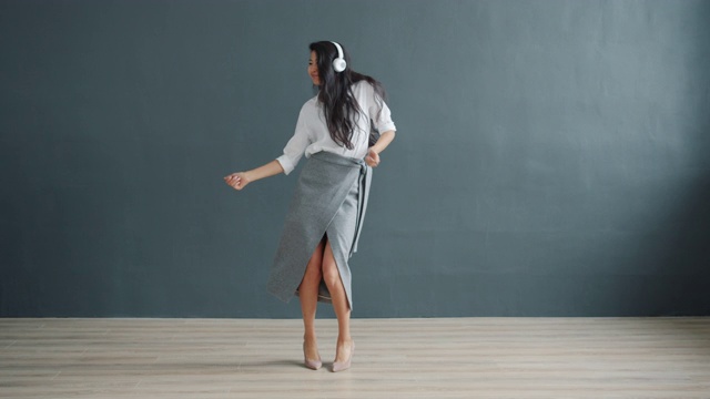 一个快乐的亚洲女人带着耳机跳舞视频下载