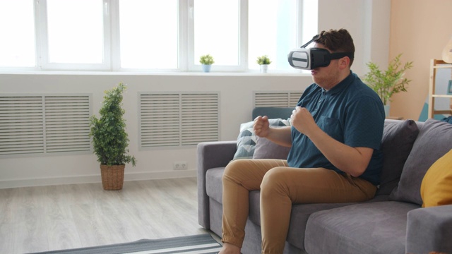 快乐的年轻人戴着虚拟现实眼镜享受拳击游戏的乐趣视频素材