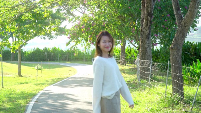 4K年轻的亚洲女人在公园里漫步视频素材