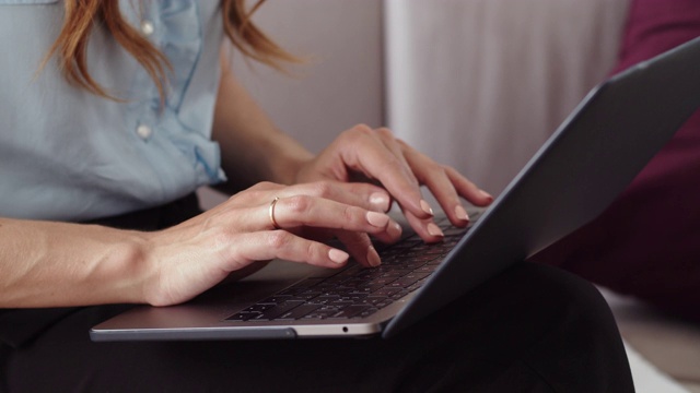 女性在远程办公室用手提电脑打字。写笔记本的女孩。视频素材