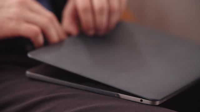 特写男子的手打字在笔记本电脑键盘在家庭办公室的慢动作。视频素材