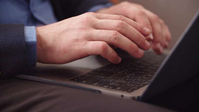 特写男性的手打字在笔记本键盘上的家庭办公室。人使用笔记本电脑视频素材
