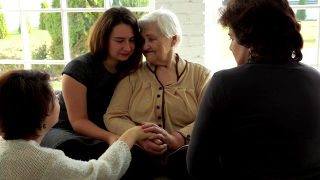 一位老妇人和她的孙女坐在沙发上视频素材